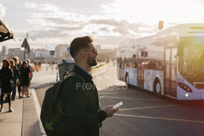 Мужчина путешествует стоя со смартфоном — стоковое фото