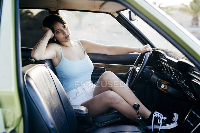 Mujer elegante sentada en el coche - foto de stock