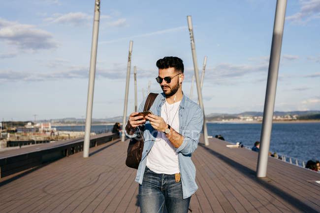 Trendy man strolling on waterfront — Stock Photo
