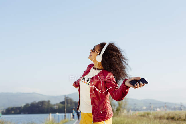 Adolescente escuchando música con auriculares - foto de stock