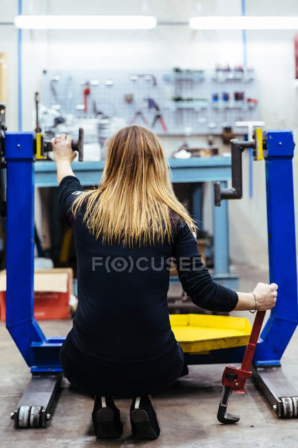 Женщина работает в механической мастерской — стоковое фото