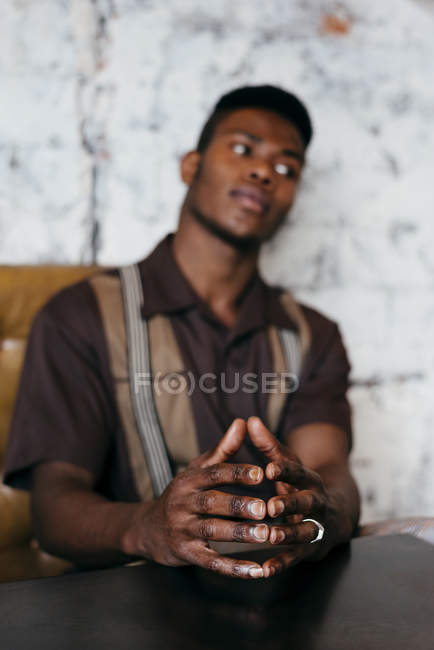 Чорний чоловік кладе руки на стіл — стокове фото