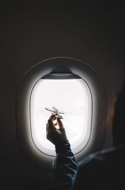 Frau zeigt Flugzeugmodell im Fenster. — Stockfoto