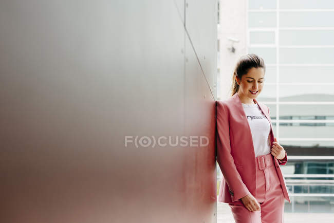 Femme en costume rose debout sur la rue — Photo de stock