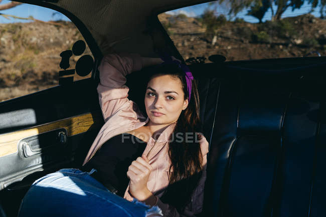 Mujer sentada en el coche - foto de stock