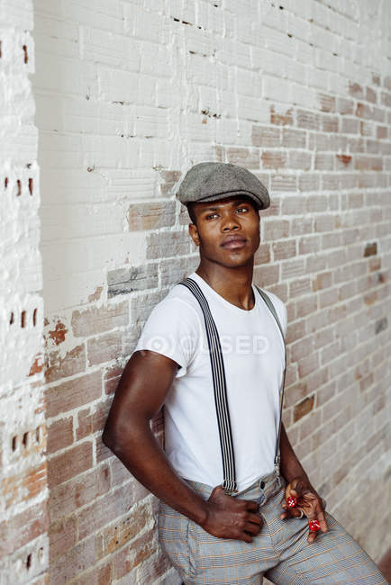 Black man in front of brick wall — Stock Photo