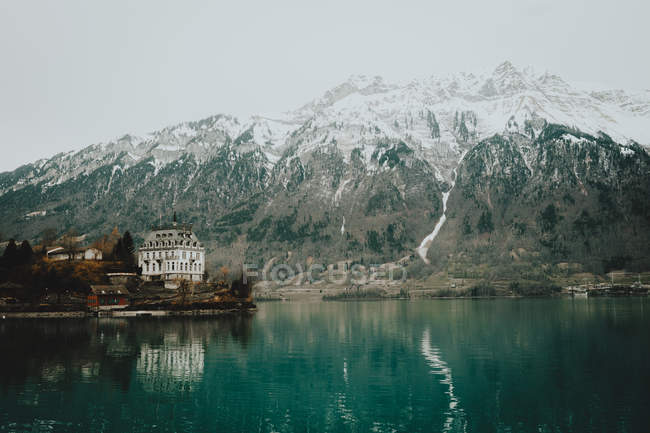 Blauer See und großes Haus am Ufer — Stockfoto