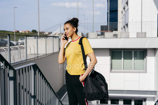 Sporty woman talking on smartphone — Stock Photo