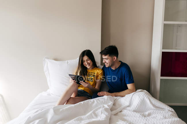 Пара використовує планшет у ліжку — стокове фото