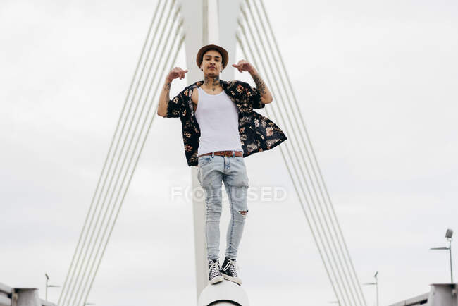 Hipster in piedi su ringhiera di ponte — Foto stock