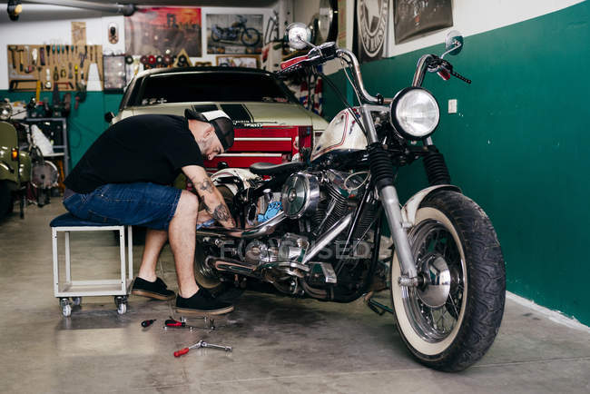 Mechanic repairing motorcycle — Stock Photo