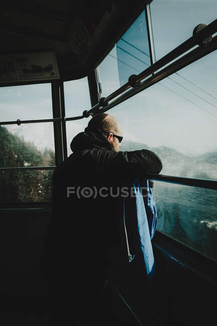 Вид збоку туриста в сонцезахисних окулярах, що їздять на мотузці на засніжених пагорбах . — стокове фото