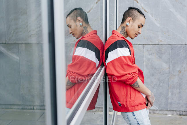 Hipster leaning against mirror wall — Stock Photo