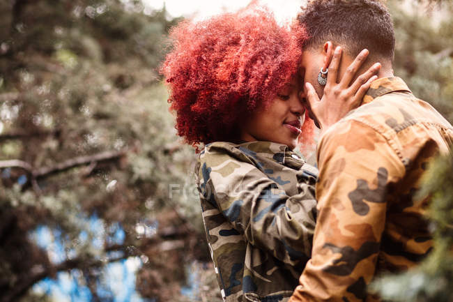 Couple embrasser parmi les arbres — Photo de stock
