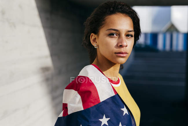 Pensive woman wrapped in USA flag — Stock Photo
