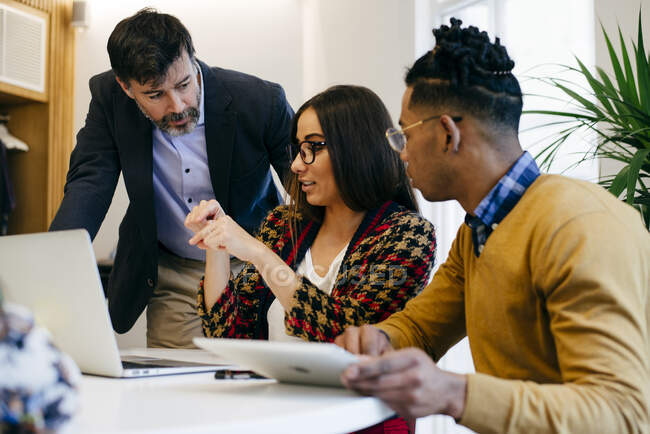Multiracial men and women workers sitting and collaborating at laptop in the office. — Stock Photo
