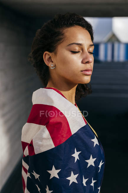 Женщина, завернутая в флаг США — стоковое фото