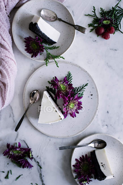 Plates with pieces of cake and flowers — Stock Photo