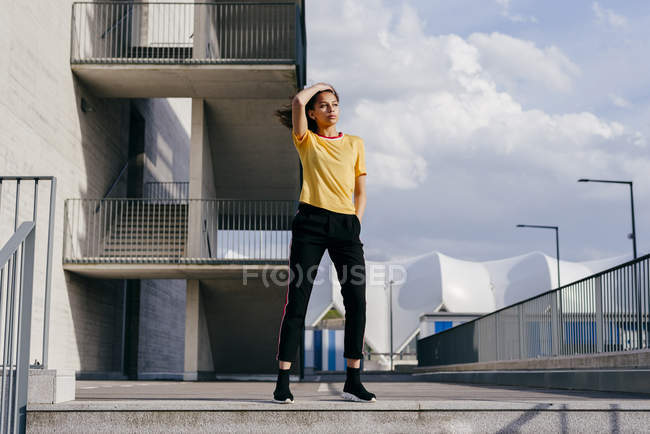 Mulher desportiva em pé na frente do edifício — Fotografia de Stock