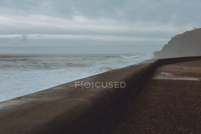 Pavimentado frente al mar vacío en tormenta - foto de stock