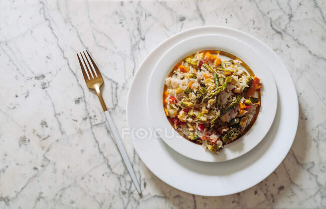 Рис басмати с овощами из соуса, на белом мраморном столе — стоковое фото