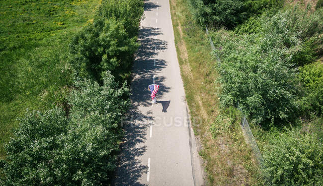 Woman walking with American flag — Stock Photo