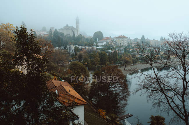 Cidade com árvores nuas e lagoa — Fotografia de Stock