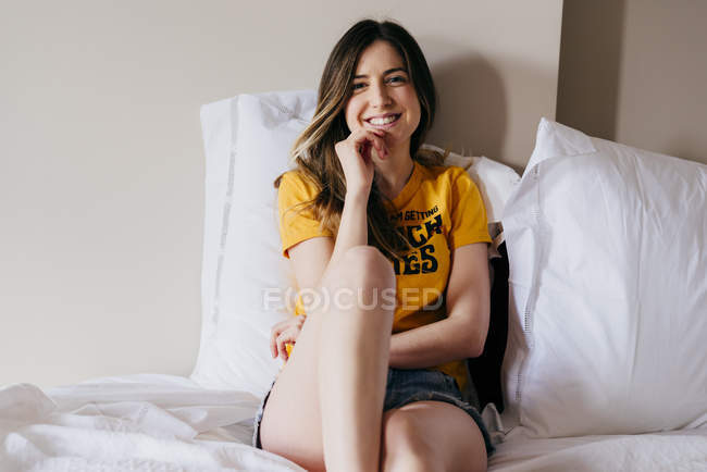 Mulher sorridente deitada na cama — Fotografia de Stock