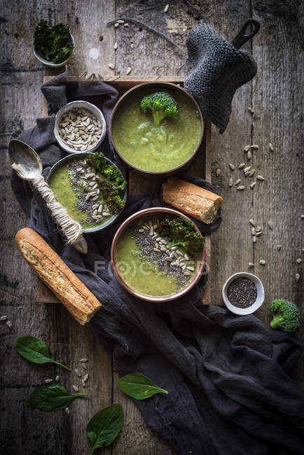 Bols de soupe verte avec brocoli sur table rustique en bois — Photo de stock