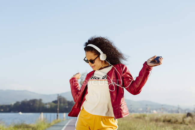 Дівчина-підліток слухає музику з навушниками — стокове фото