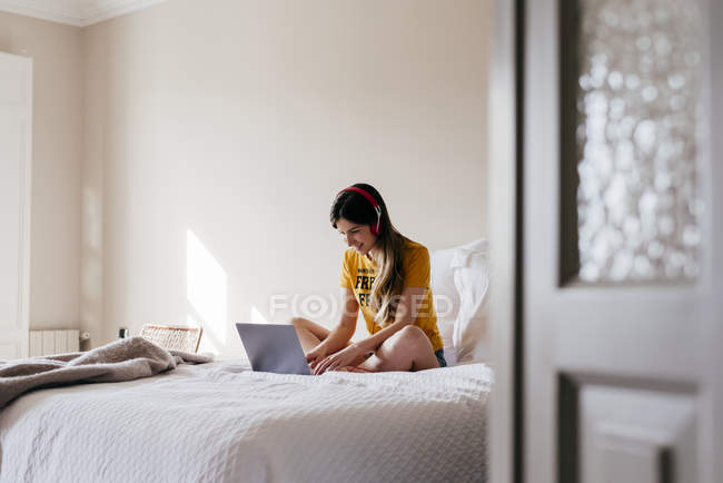 Woman in headphones using laptop — Stock Photo