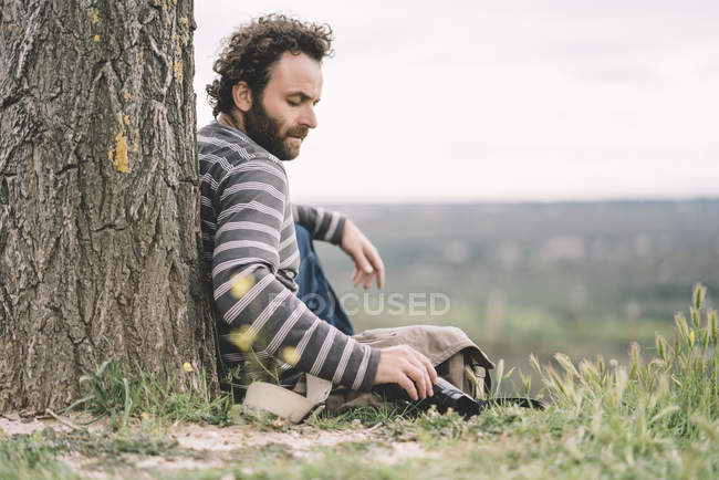 Чоловічий фотожурналіст, сидячи за допомогою камери — стокове фото