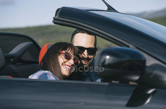 Hombre y mujer viajan en coche descapotable. - foto de stock