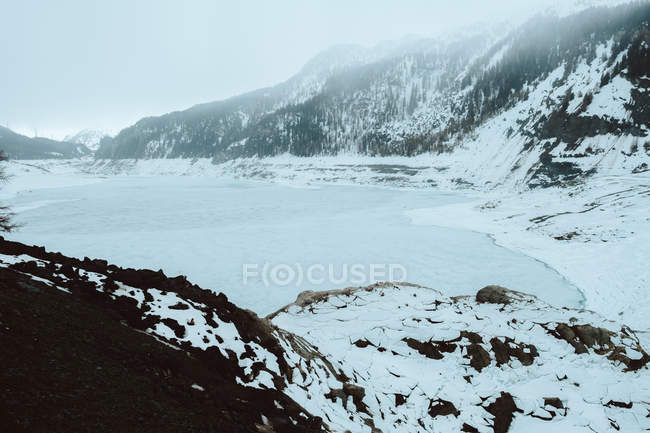 Lac gelé dans les montagnes enneigées — Photo de stock