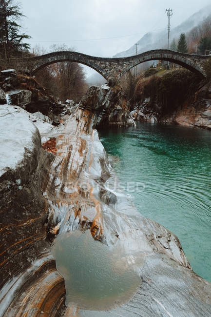 Wellige Brücke über den blauen Fluss — Stockfoto