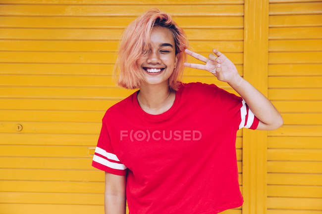 Lachende Frau zeigt Friedenszeichen — Stockfoto