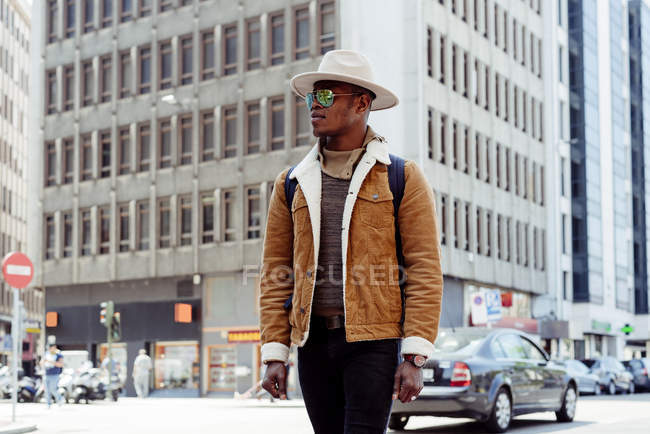 Черный человек, идущий по улице — стоковое фото