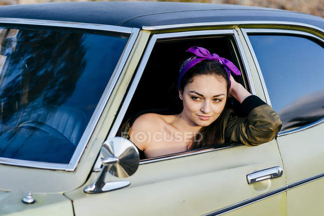 Femme assise dans une voiture vintage — Photo de stock