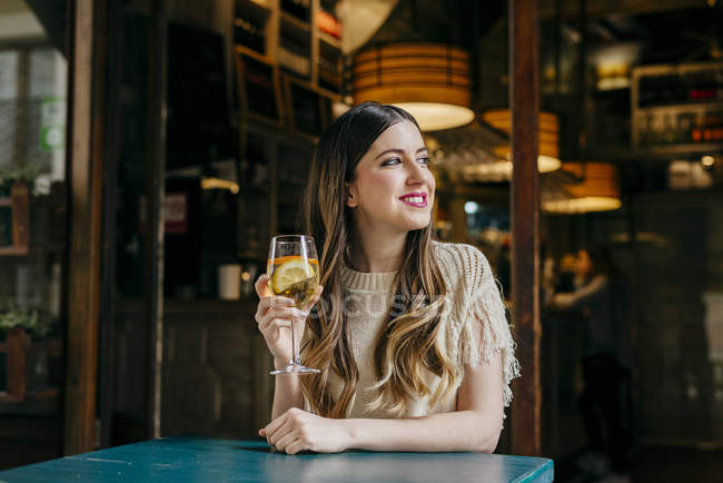 Femme avec boisson assis dans un café — Photo de stock