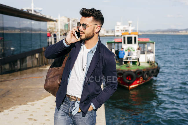 Homem com mochila falando no telefone — Fotografia de Stock
