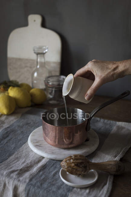 Hand pouring lemon juice — Stock Photo