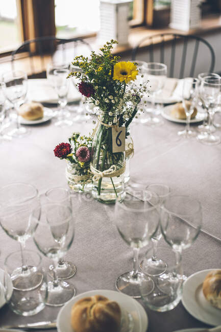 Bright beautiful rustic flowers in bottle on served banquette table. — Stock Photo