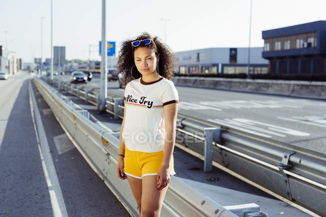 Дівчина-підліток стоїть на шосе — стокове фото