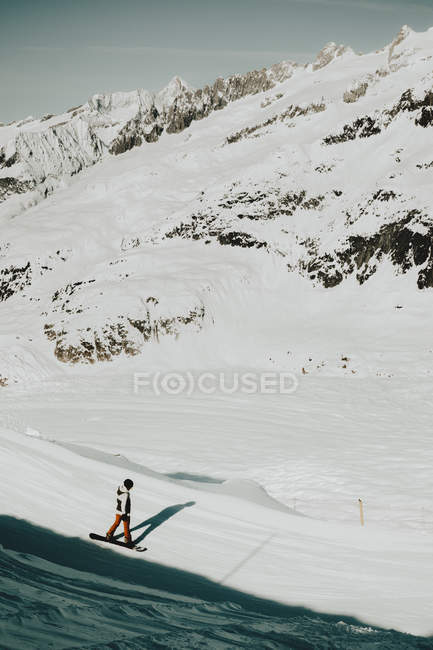 Людина катається на сноуборді на пагорбі — стокове фото