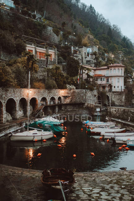 Boats anchored in channel of small town — Stock Photo