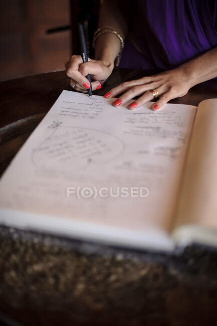 Ernte unkenntlich Frau schreibt Wünsche in das Tagebuch. — Stockfoto