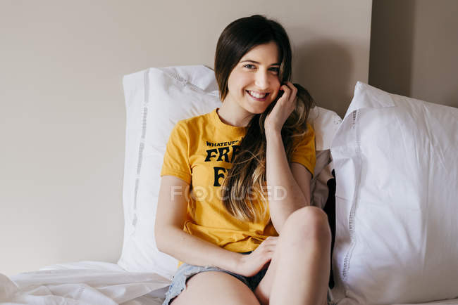 Улыбающаяся женщина лежит в постели — стоковое фото