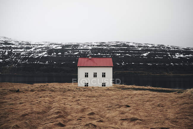 Petite maison sur colline enneigée — Photo de stock