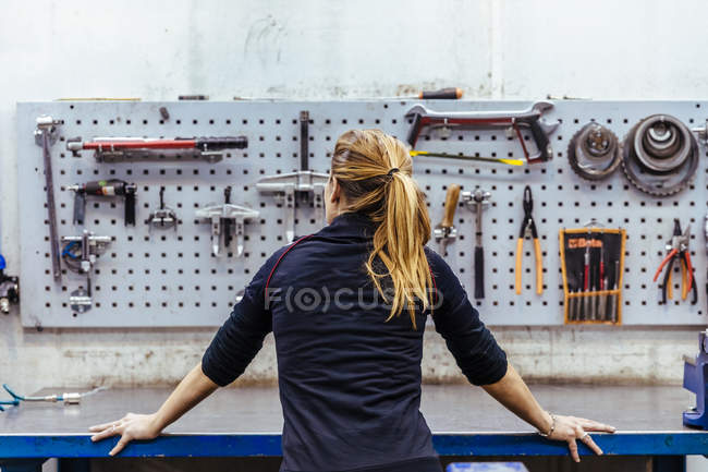 Woman standing in mechanical workshop — Stock Photo