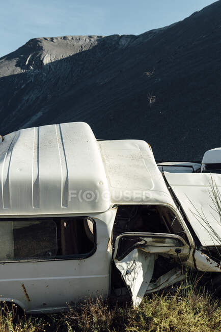 Altes Auto in der Nähe eines schwarzen Kieshaufens in einem Steinbruch mit zerbrochener Karosserie — Stockfoto